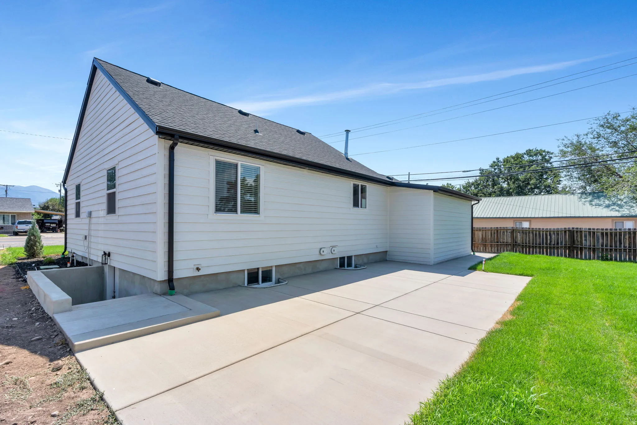 Expansive concrete patio with a manicured lawn area