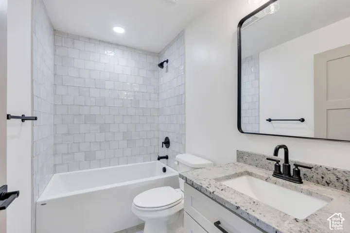 Modern bathroom featuring a vanity with a light-toned countertop, an integrated sink, and matte black hardware