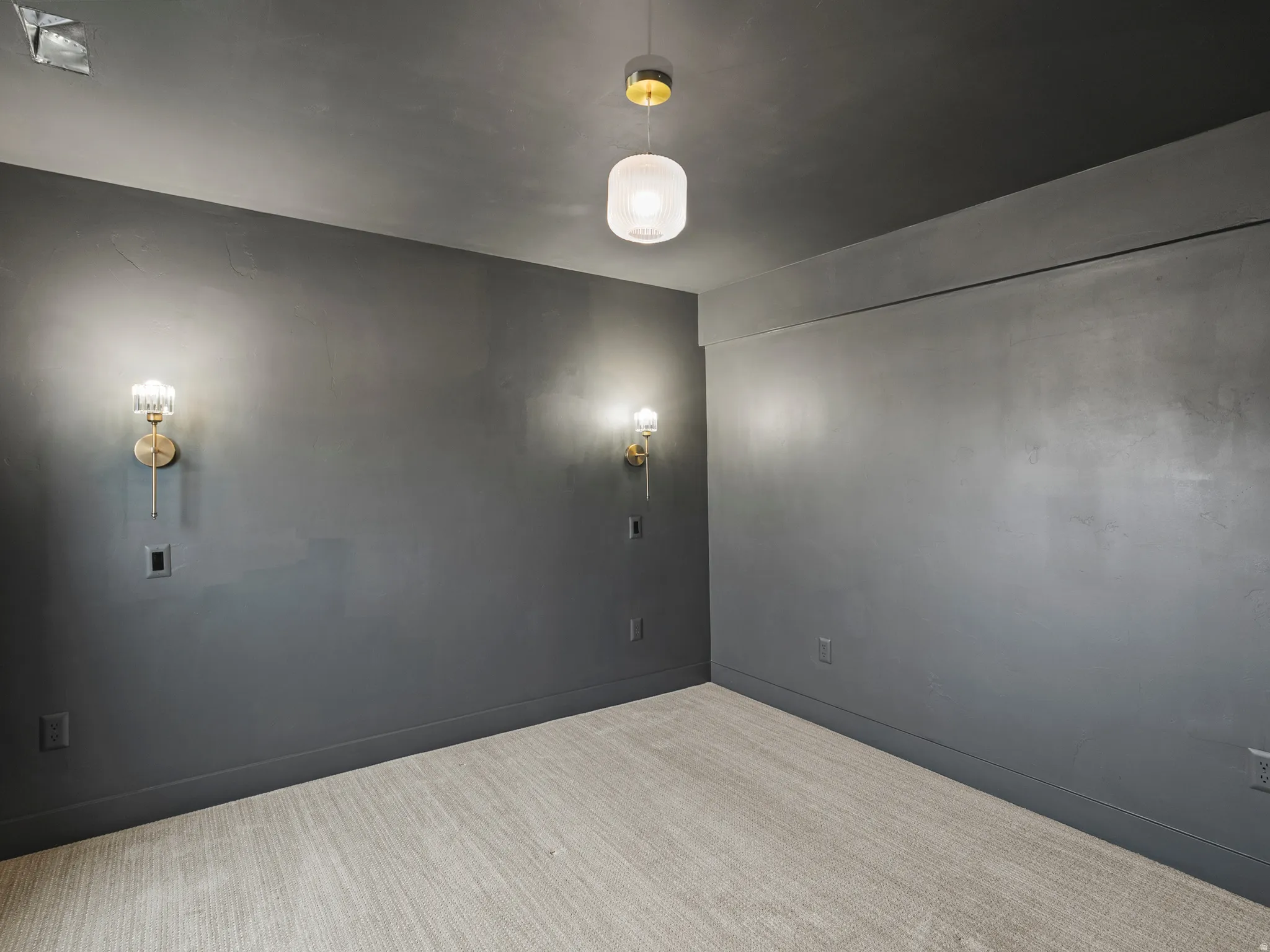 Deep gray walls with coordinating baseboards and a light patterned carpet