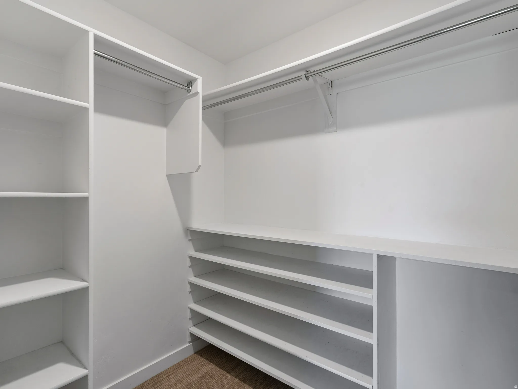 Customizable closet system with built-in shelving, hanging rods, and wood-finish flooring