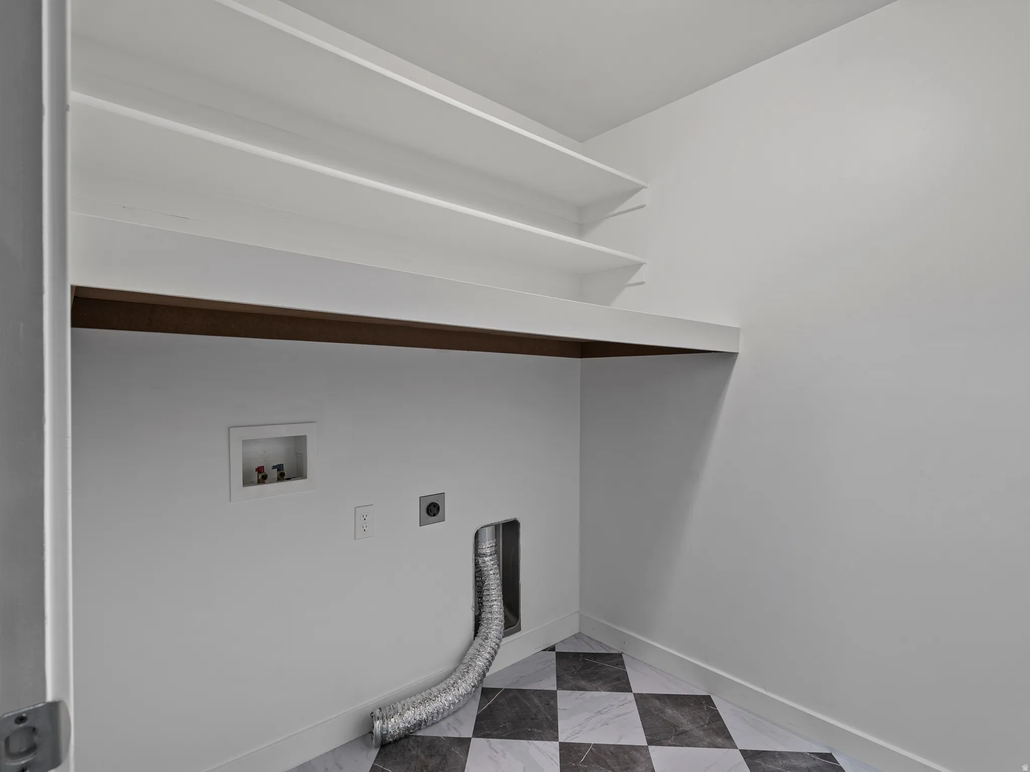 Utility room featuring checkerboard tile flooring, recessed wall outlets, and flexible ducting infrastructure