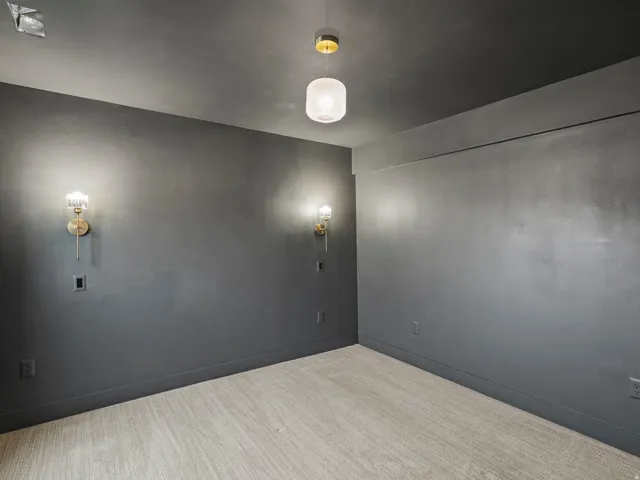 Deep gray walls with coordinating baseboards and a light patterned carpet
