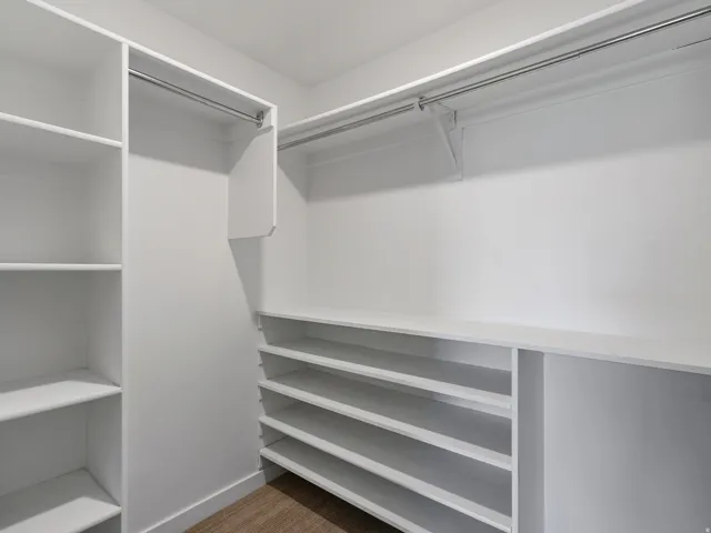 Customizable closet system with built-in shelving, hanging rods, and wood-finish flooring