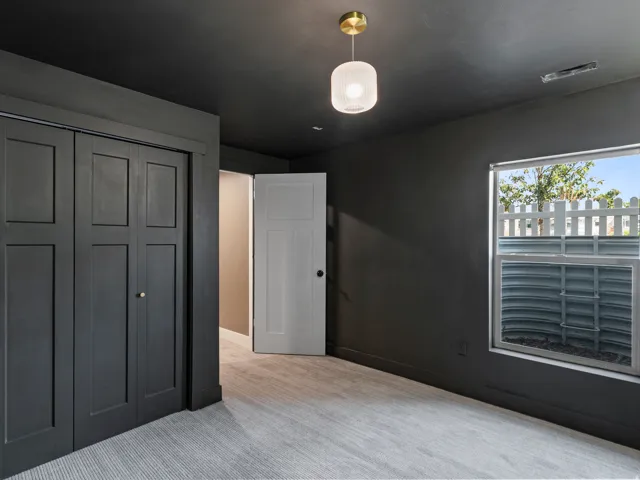 Room featuring a window, light gray carpet, and dark gray walls