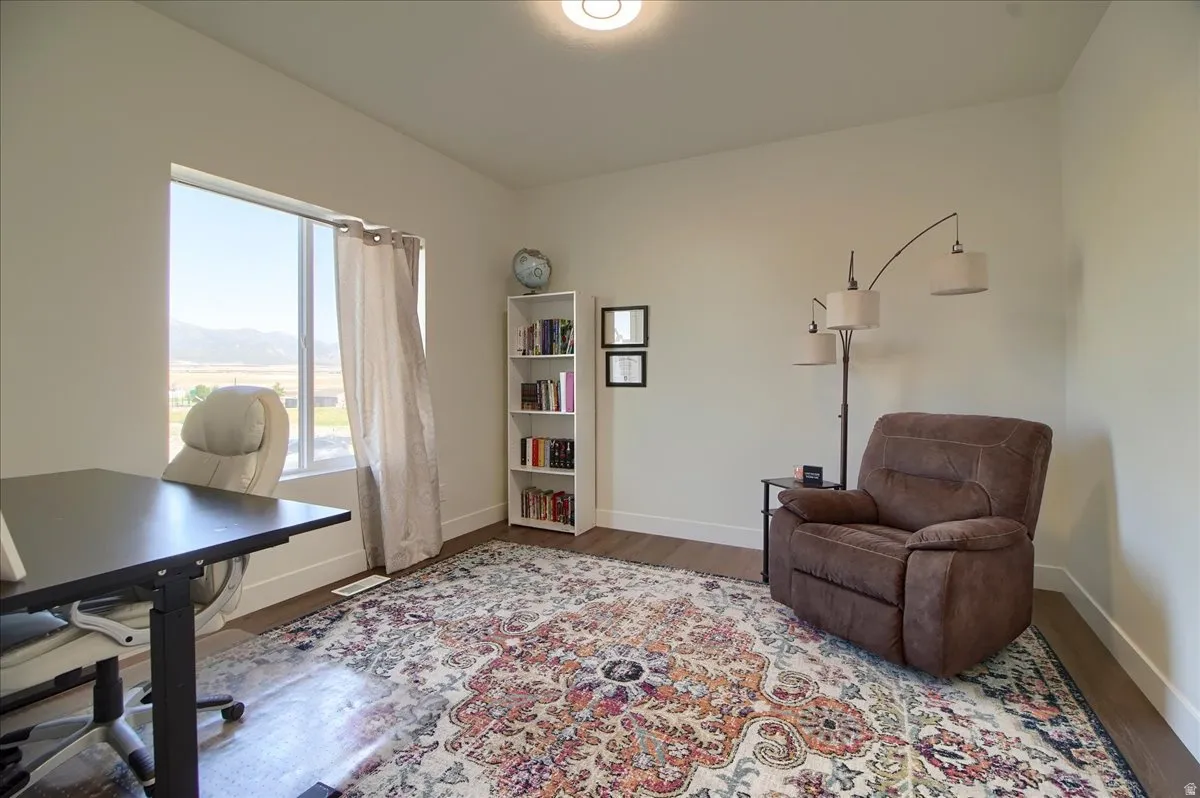 Hardwood-finish flooring anchors a room with a large window offering expansive mountain scenery
