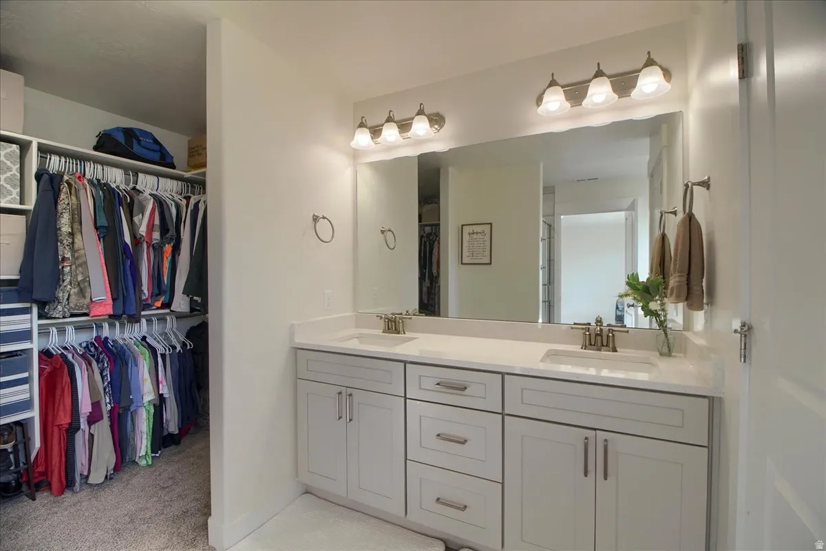 Dual vanity featuring gray shaker cabinetry with contemporary hardware, white countertops, and undermount sinks