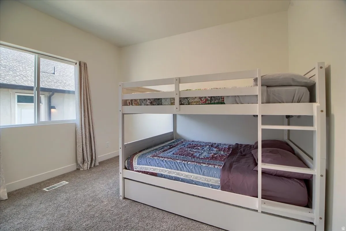 Carpeted room with a large window and white trim