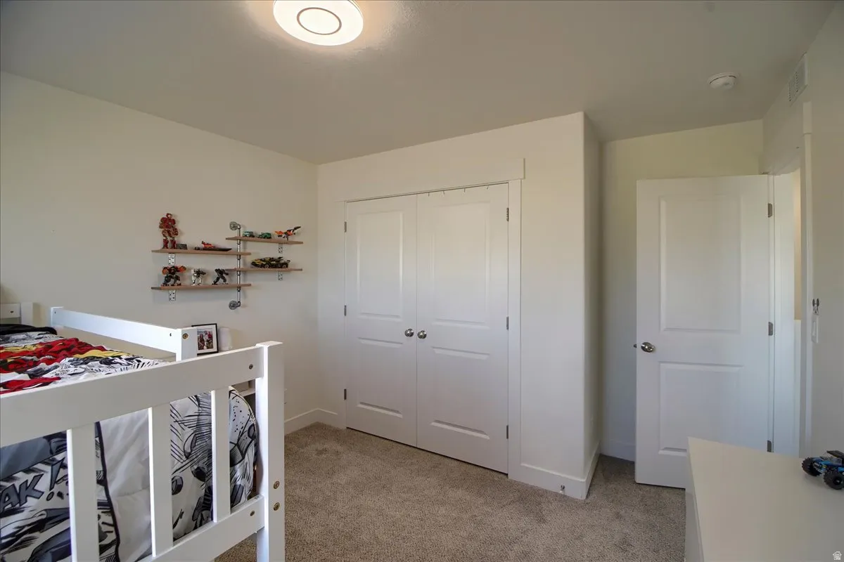 Recessed lighting illuminates neutral-toned walls and plush carpet flooring