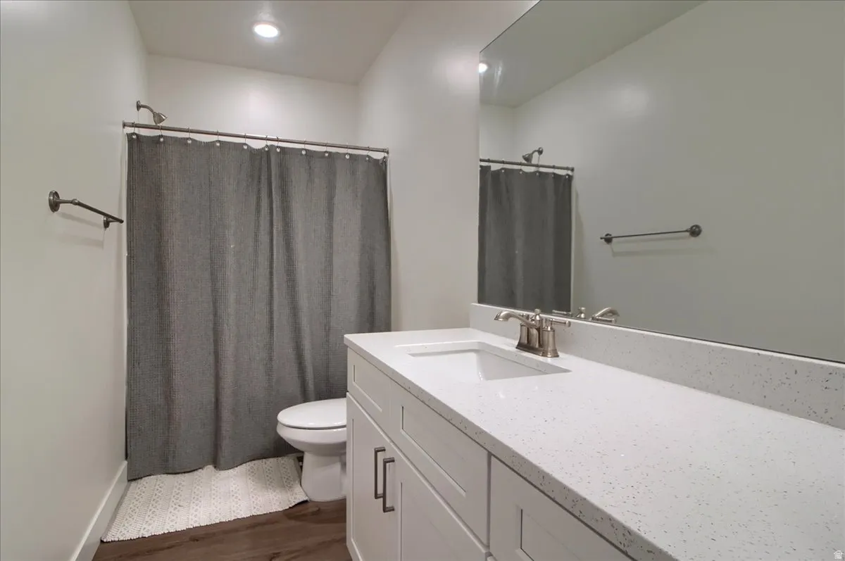 Bathroom featuring a white vanity with recessed panel cabinetry, brushed nickel hardware, and a light-toned countertop