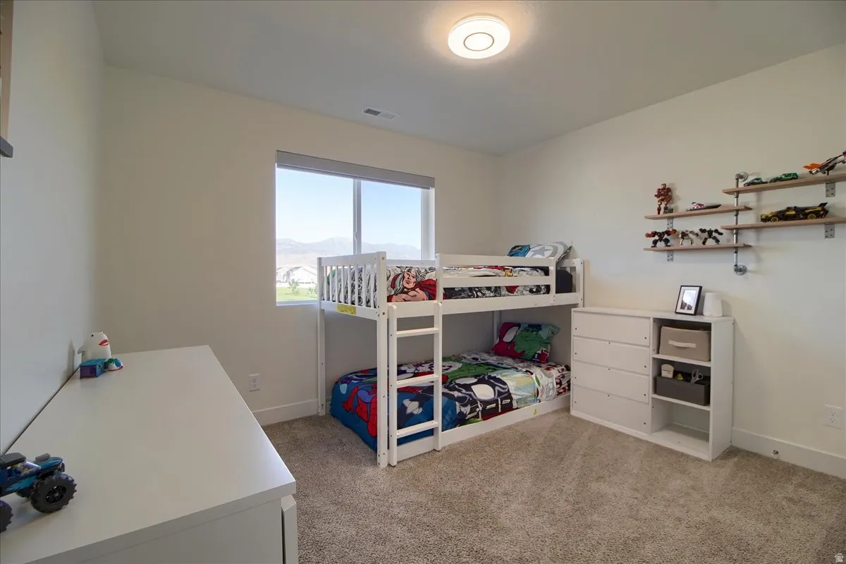 Bright room featuring neutral wall tones, a large window, and light-colored carpeting