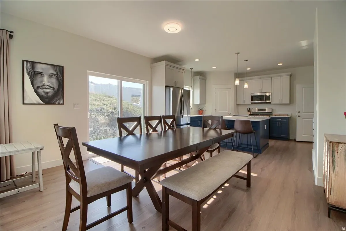 Open-concept living space featuring wood-finish flooring, a sliding glass door, and recessed lighting
