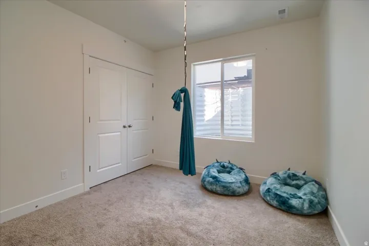 Neutral toned carpet flooring and white walls, featuring a double-door closet with panel detailing