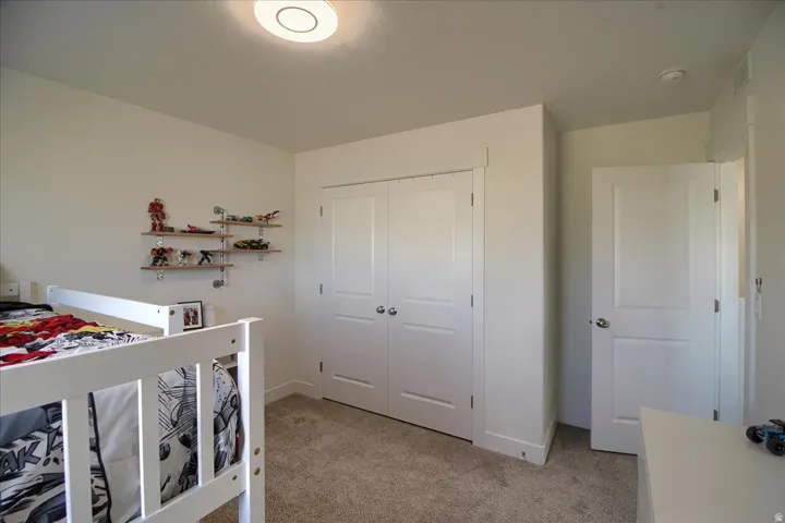 Recessed lighting illuminates neutral-toned walls and plush carpet flooring