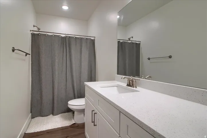 Bathroom featuring a white vanity with recessed panel cabinetry, brushed nickel hardware, and a light-toned countertop