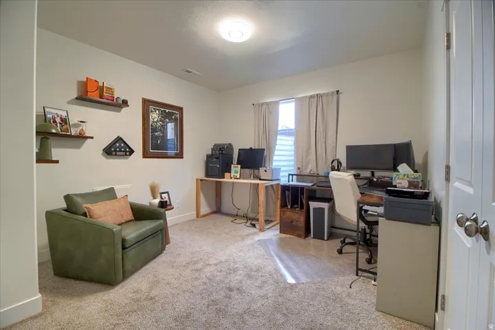 Carpeted room featuring a ceiling-mounted light fixture, a window with horizontal blinds, and a white paneled door