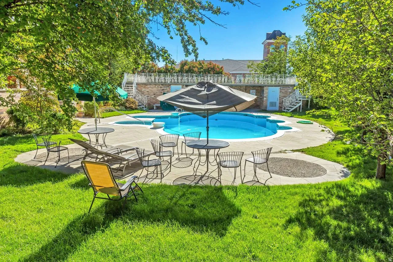 Expansive outdoor space featuring a kidney-shaped swimming pool with an integrated hot tub