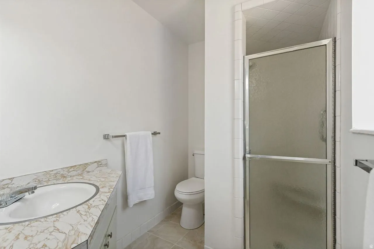 Bathroom featuring a vanity with a white oval sink, patterned countertop, and chrome faucet