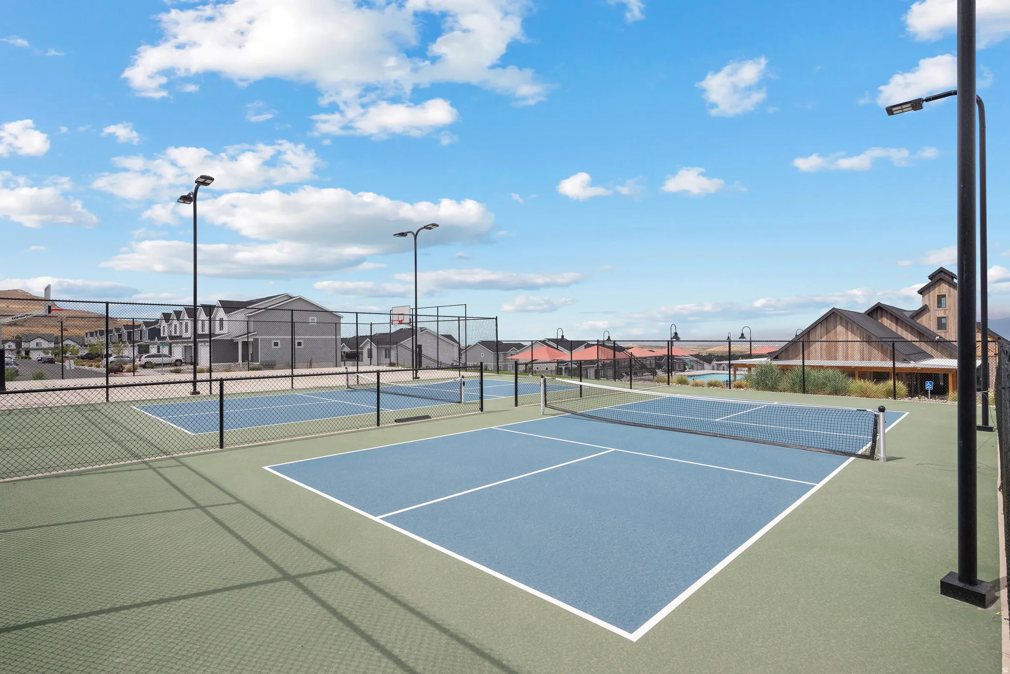 Recreational sports courts featuring a blue playing surface and green surrounding area