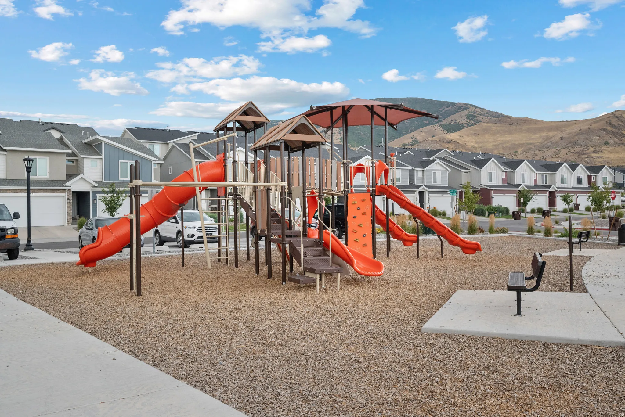 Community playground featuring multiple slides, climbing elements, and protective ground covering