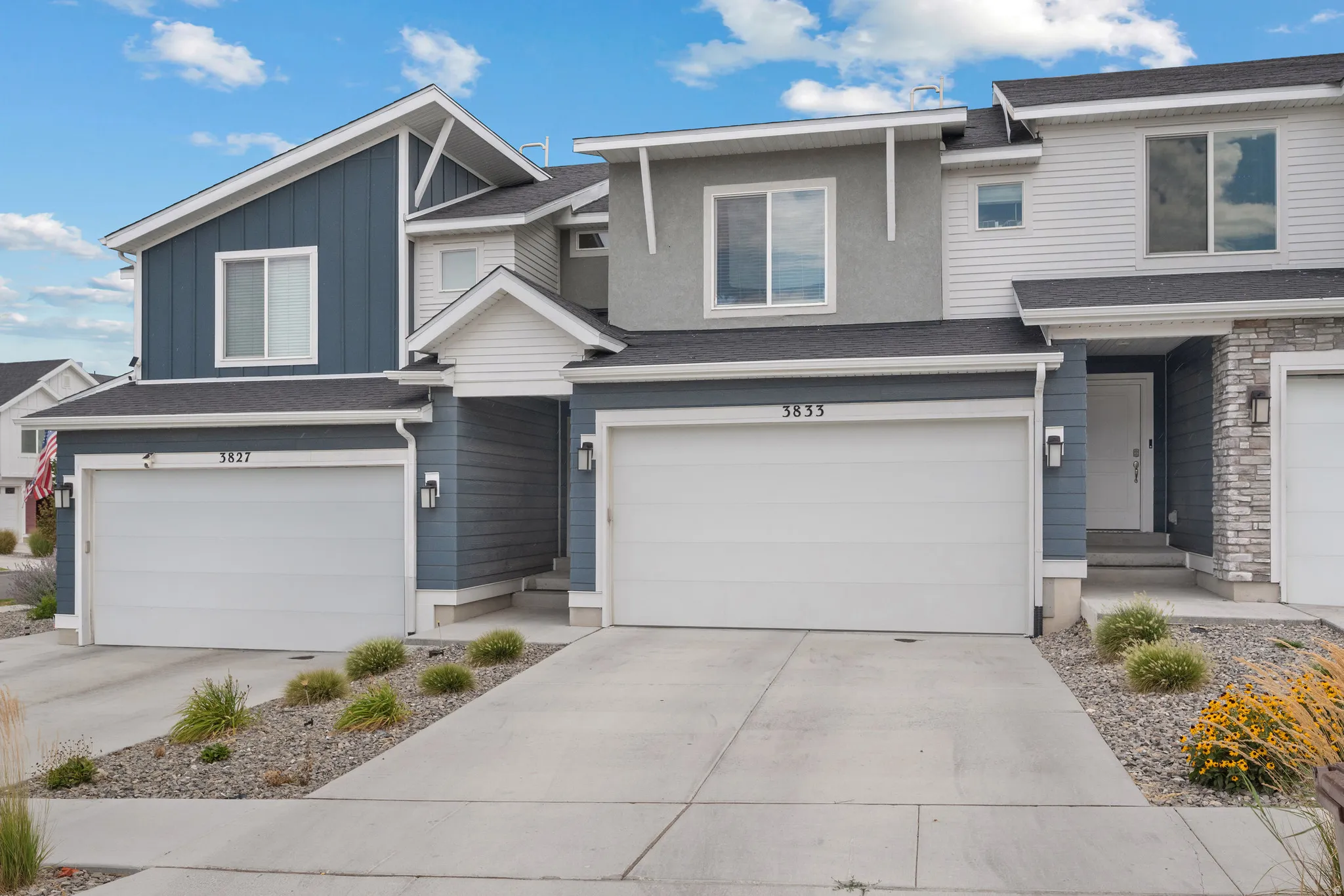 Contemporary townhome community featuring two-story architecture with mixed exterior finishes including board-and-batten siding and stone accents