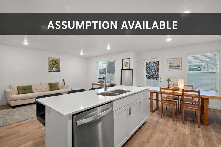 Kitchen island with stainless steel sink, wood-finish flooring, white cabinetry, recessed lighting, and a stainless steel dishwasher