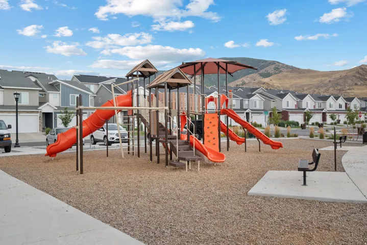Community playground featuring multiple slides, climbing elements, and protective ground covering