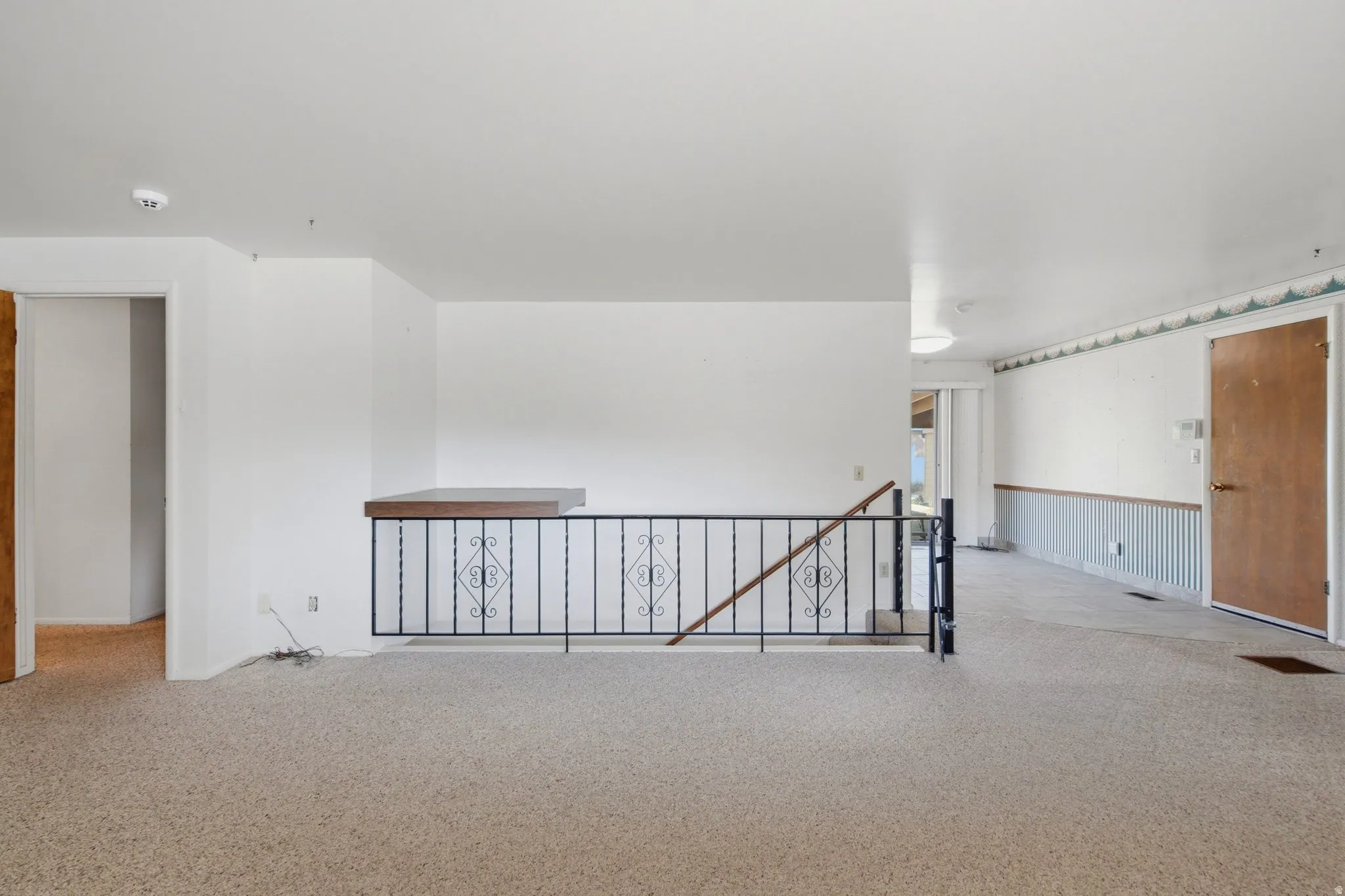 Spacious interior featuring neutral carpeting and white walls