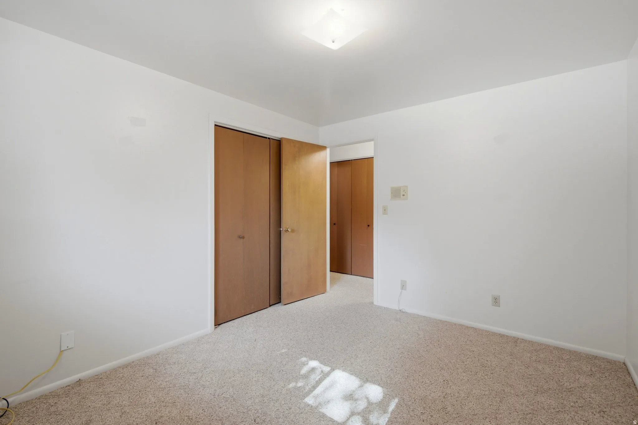 Neutral-toned wall-to-wall carpeting complements the white painted walls