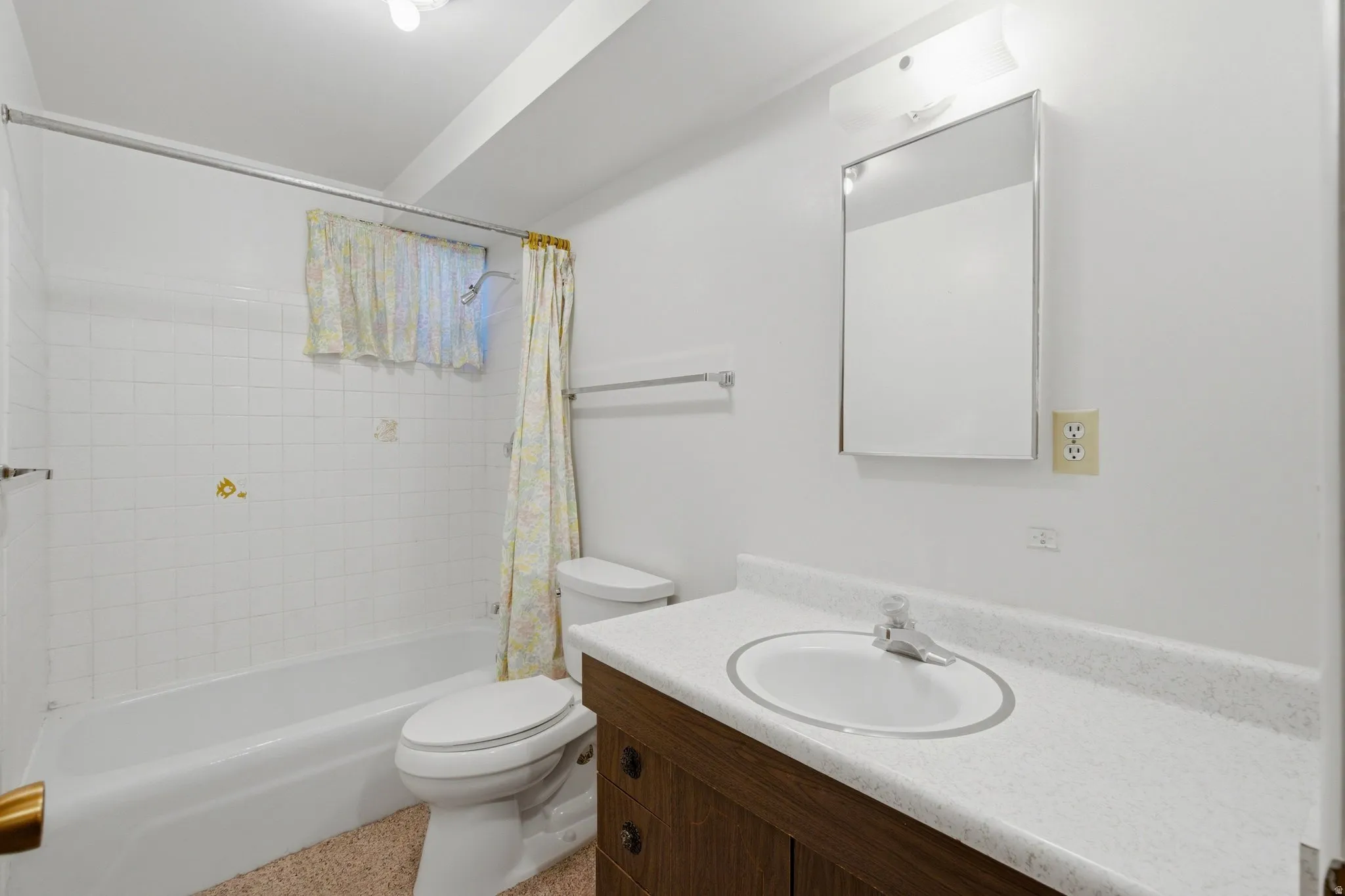 Clean and functional bathroom featuring a wood-finish vanity with dual drawers, white ceramic sink, and white quartz countertop