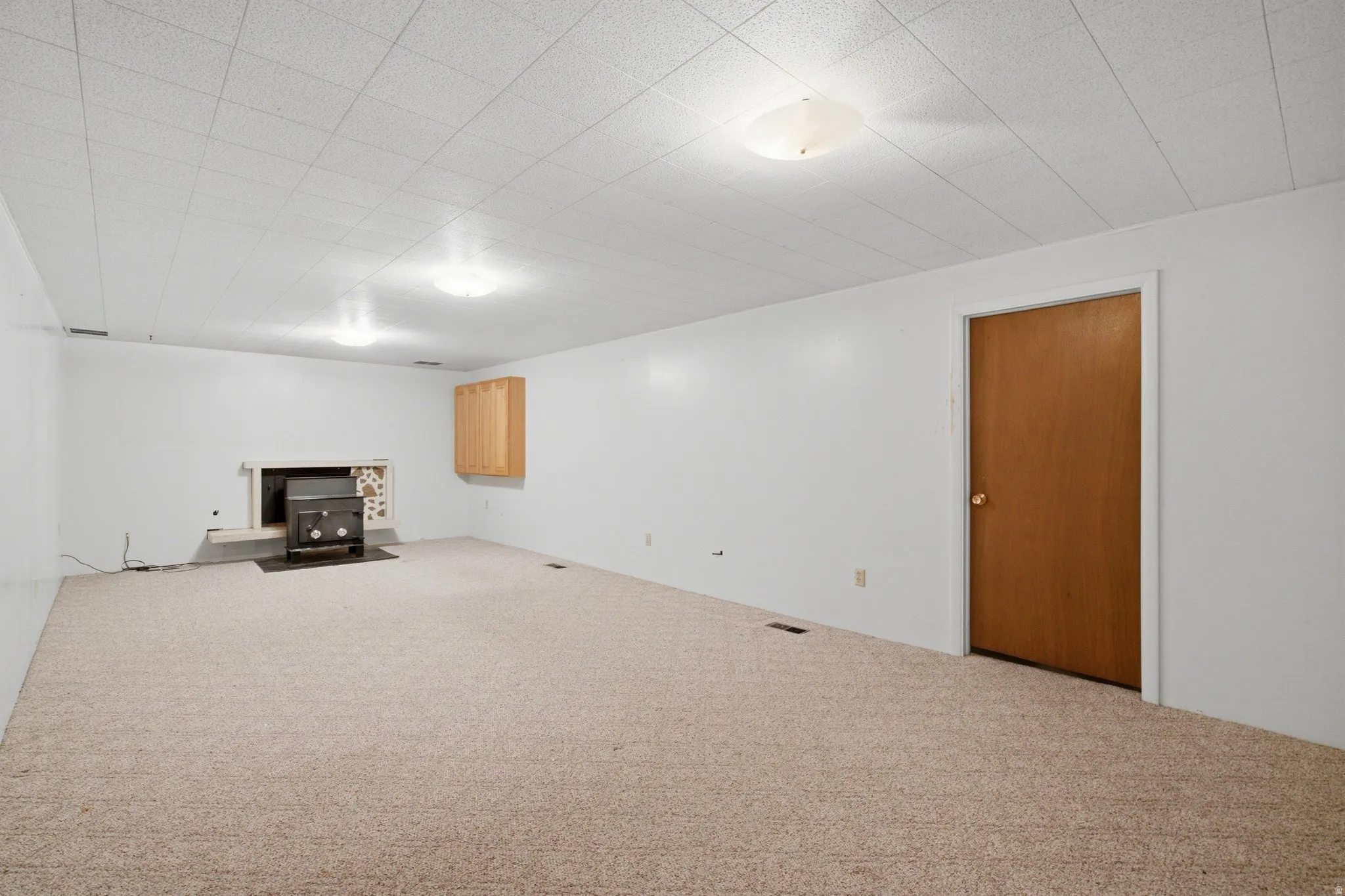 Spacious room featuring neutral carpeting and white walls