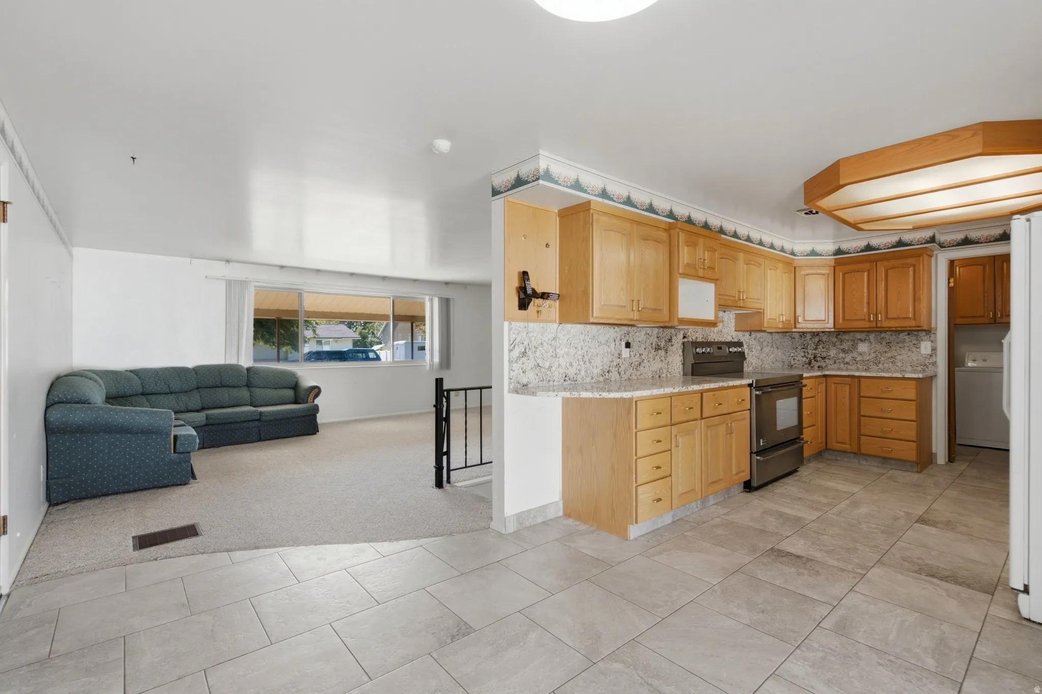 Kitchen featuring wood cabinetry, stone countertops, and tile flooring