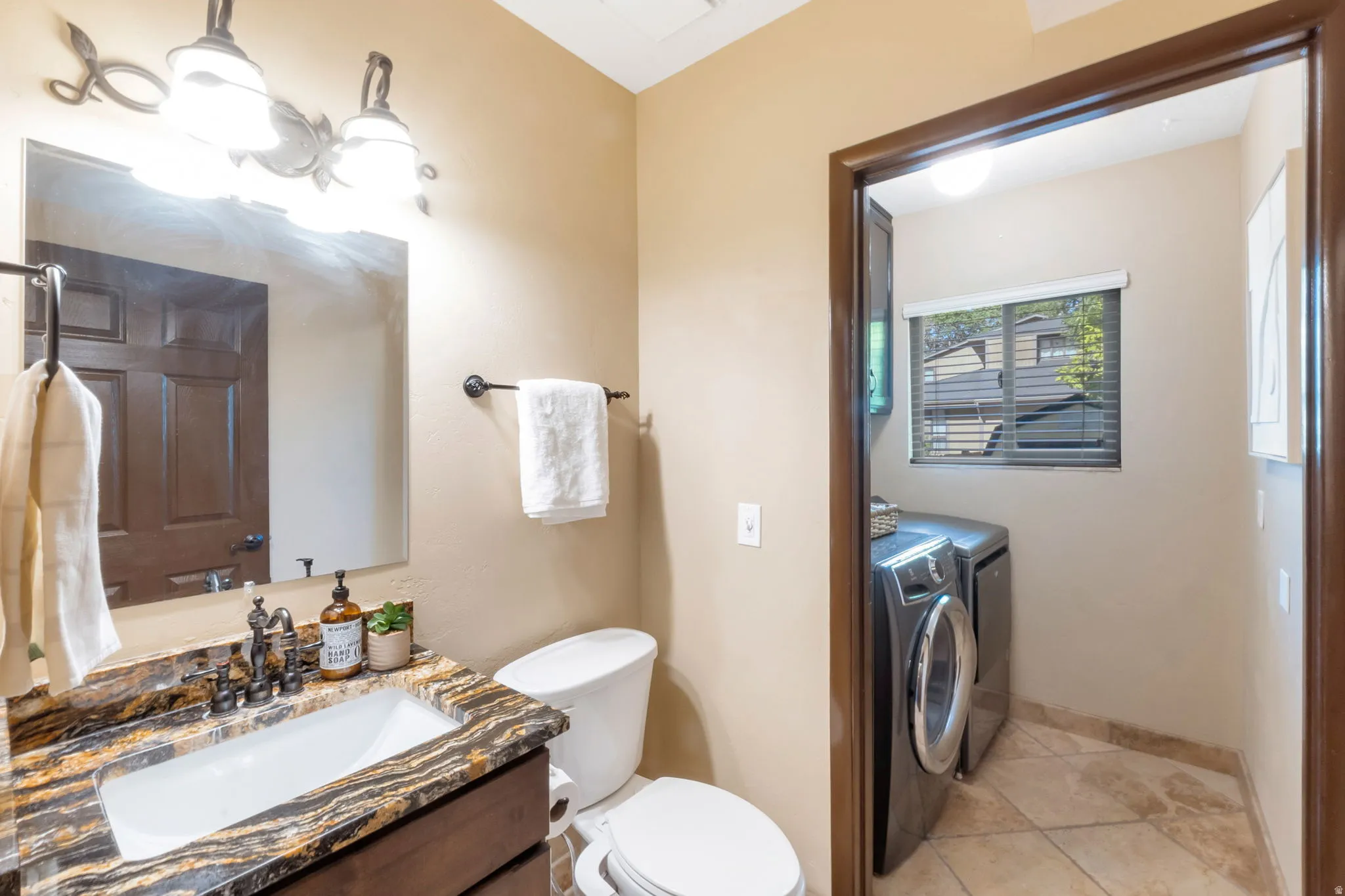 Bathroom featuring a dark wood vanity with a granite countertop, undermount sink, and dark bronze fixtures