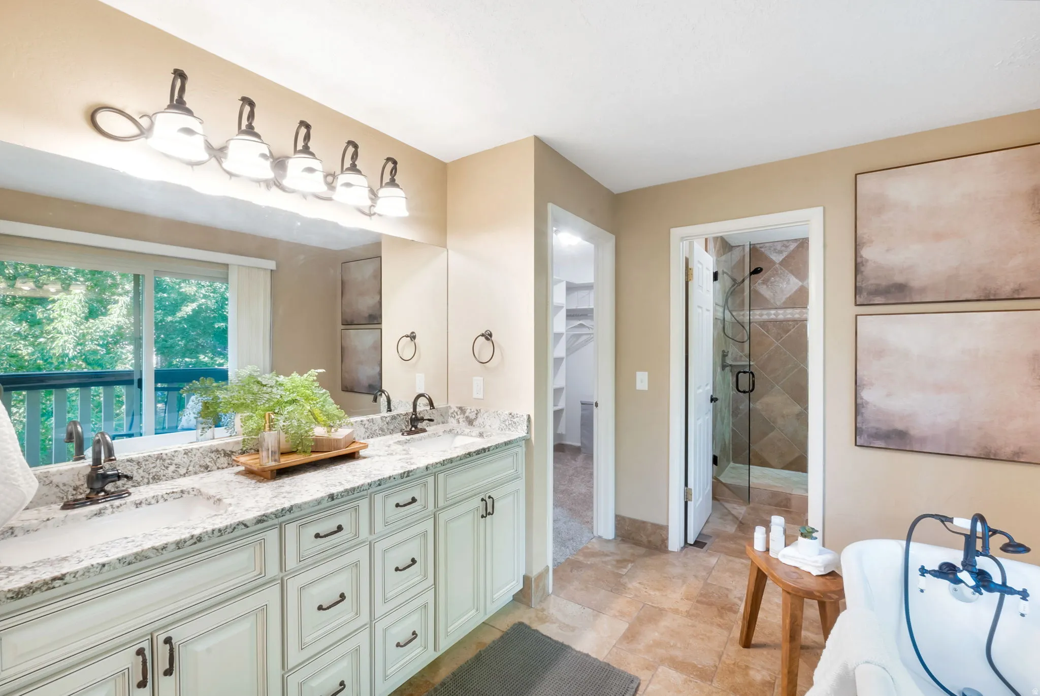 Double vanity featuring granite countertops, undermount sinks, and light-toned cabinetry