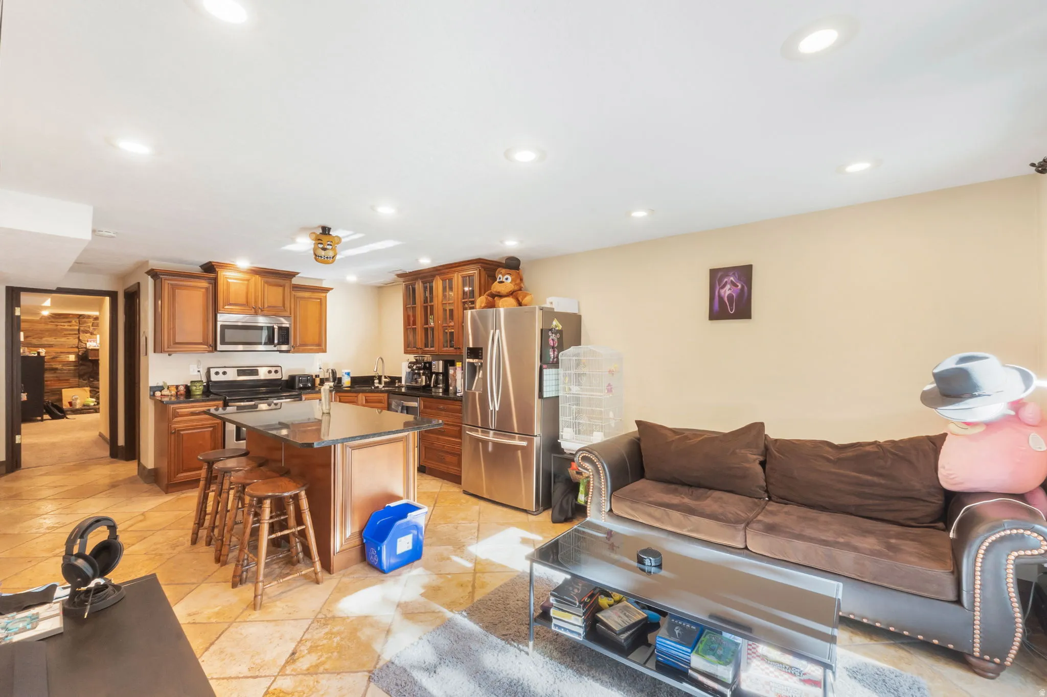Kitchen featuring wood cabinetry, stainless steel appliances, and a central island with countertop seating
