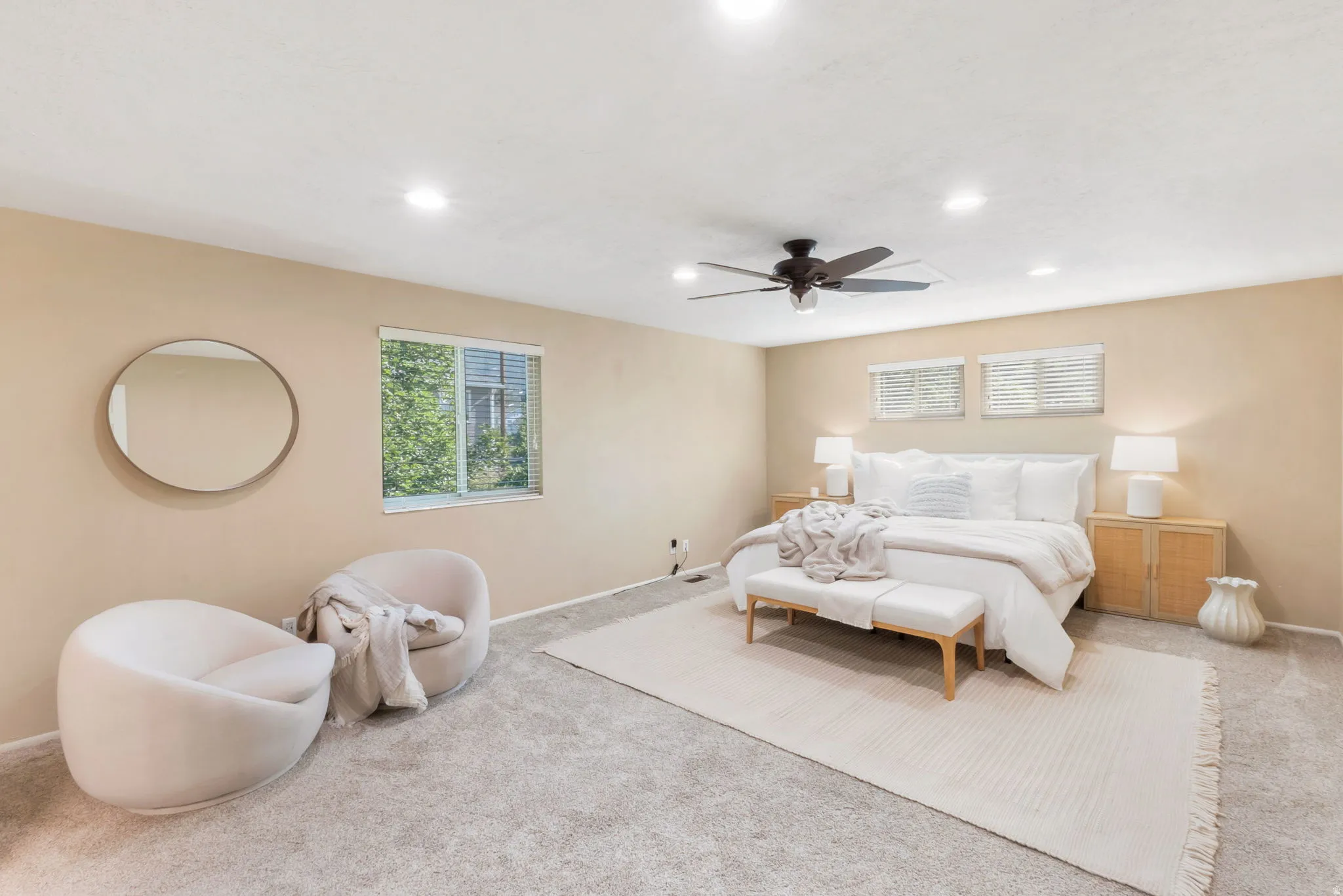 Spacious interior featuring neutral wall tones, recessed lighting, ceiling fan, and carpeted flooring