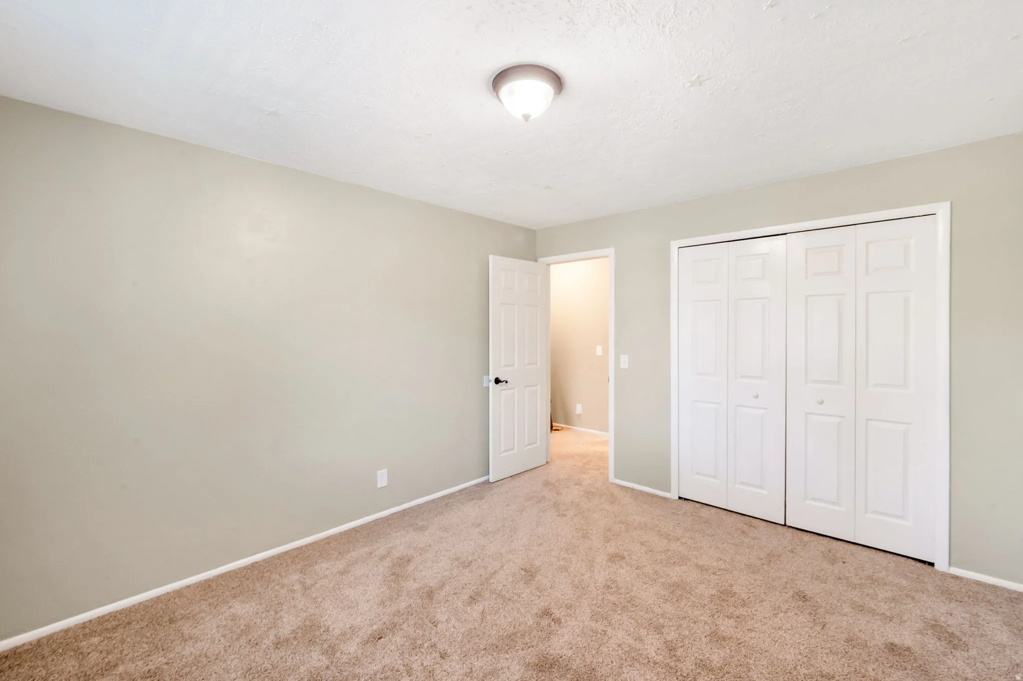Neutral tone walls with white trim and a textured ceiling