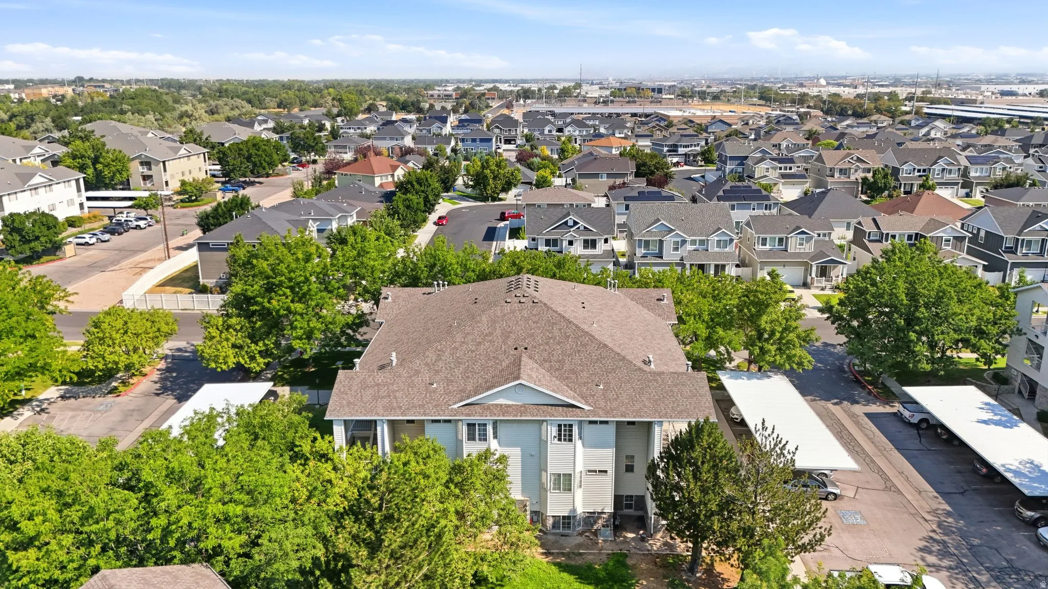 Multi-story residential building featuring a gabled roof and covered parking areas