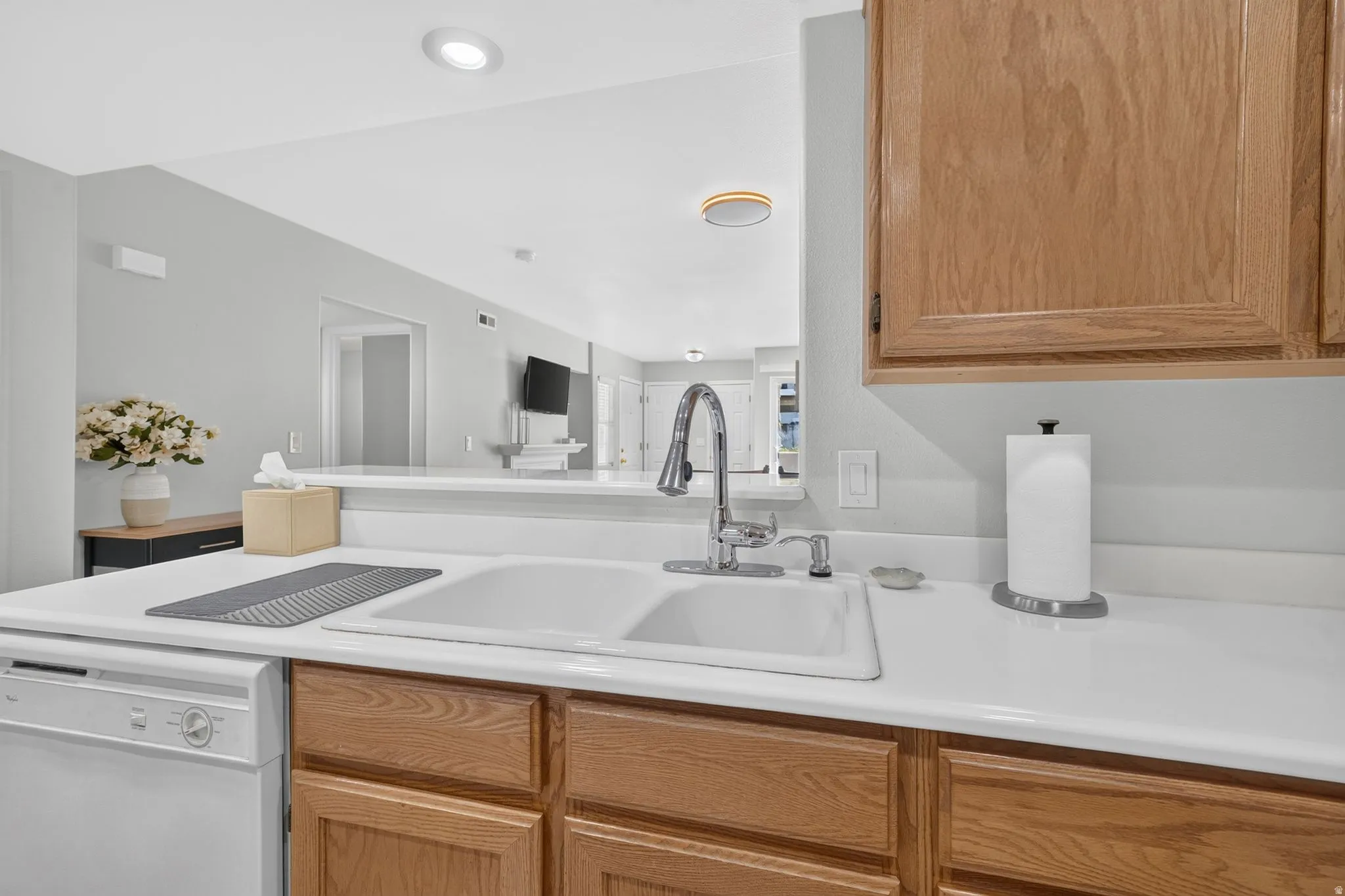 Kitchen sink area featuring a white double-basin sink with a gooseneck faucet
