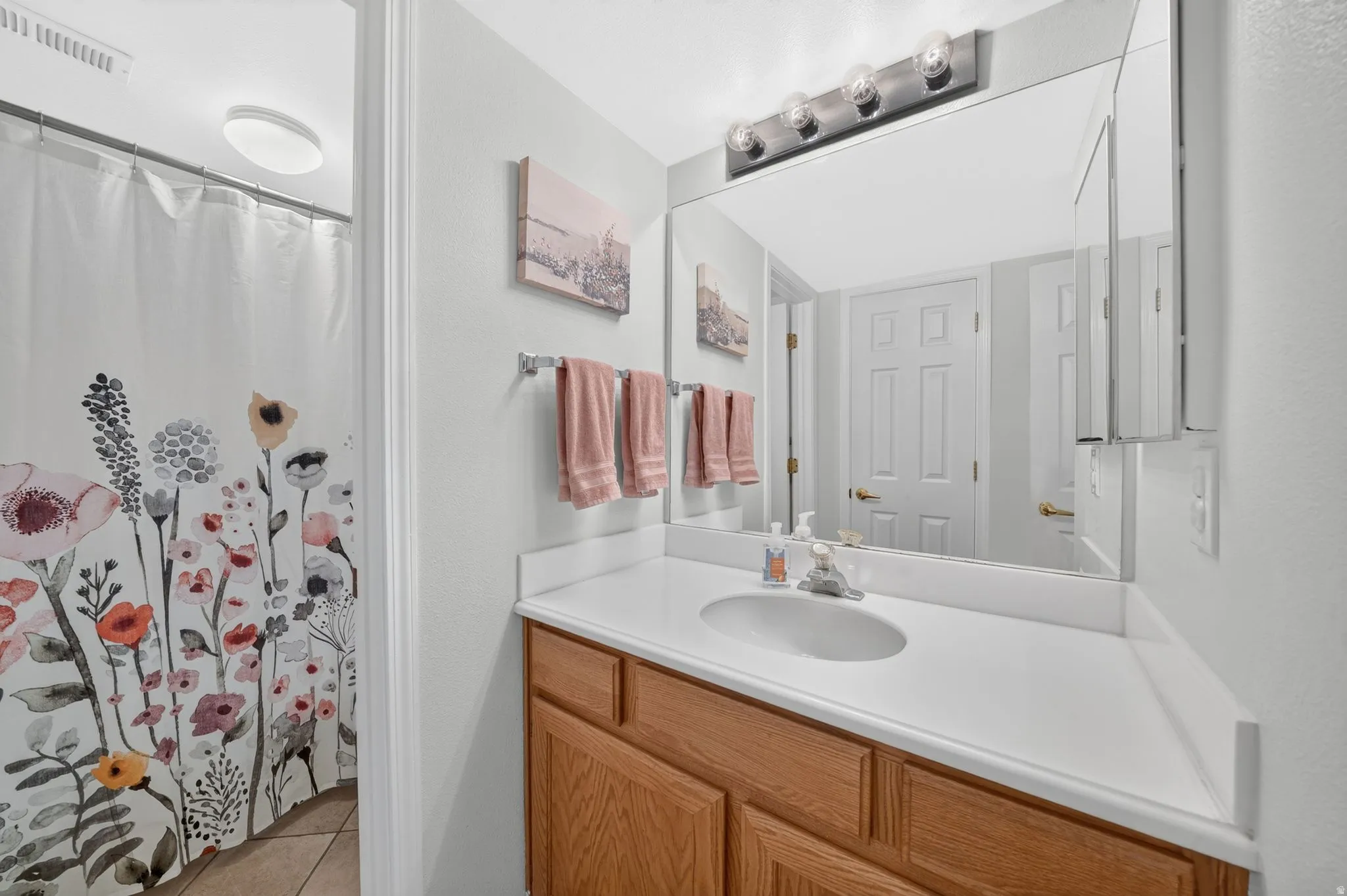 Spa-inspired bathroom featuring a wood-finish vanity with ample storage, white quartz countertop, and an undermount sink