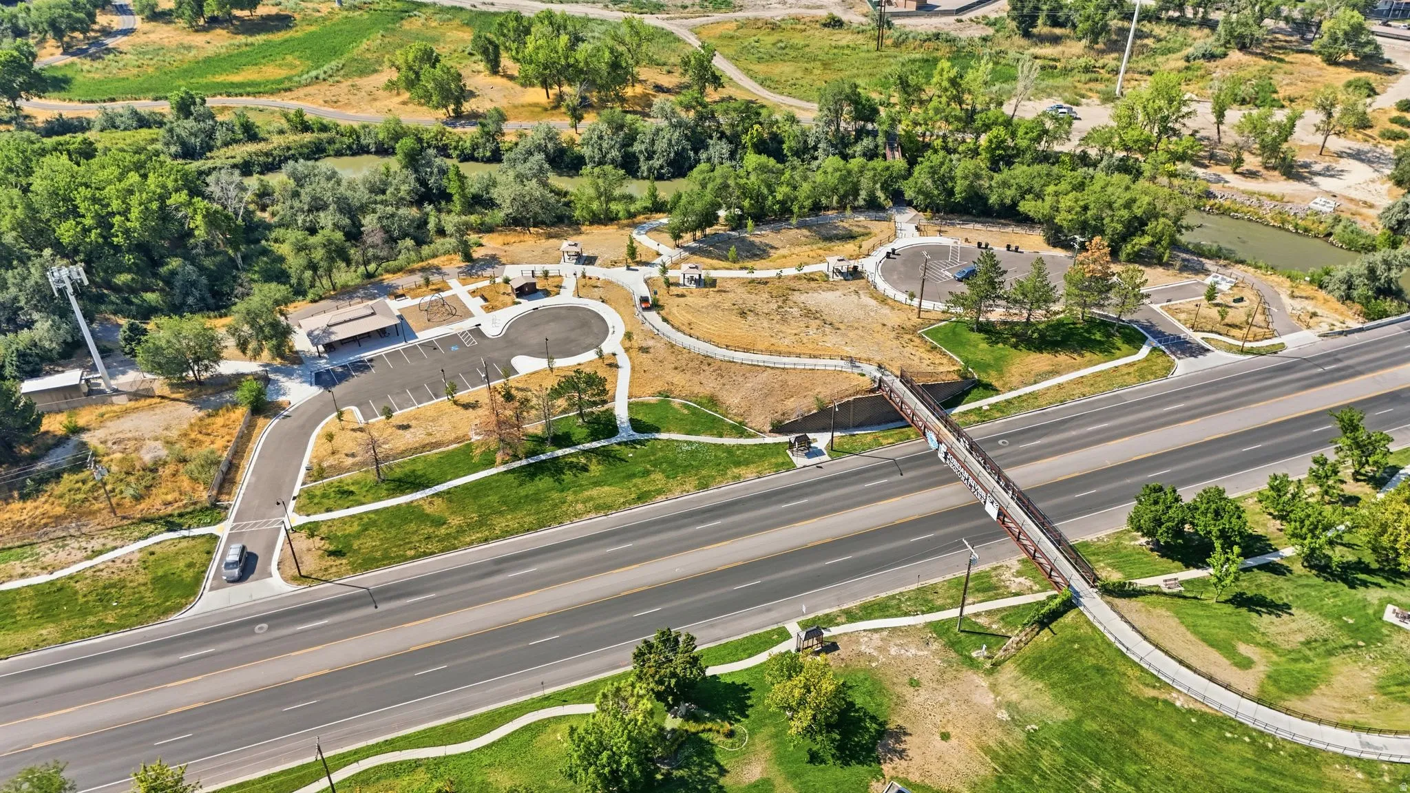 Aerial perspective of a multi-lane roadway with an overhead pedestrian bridge