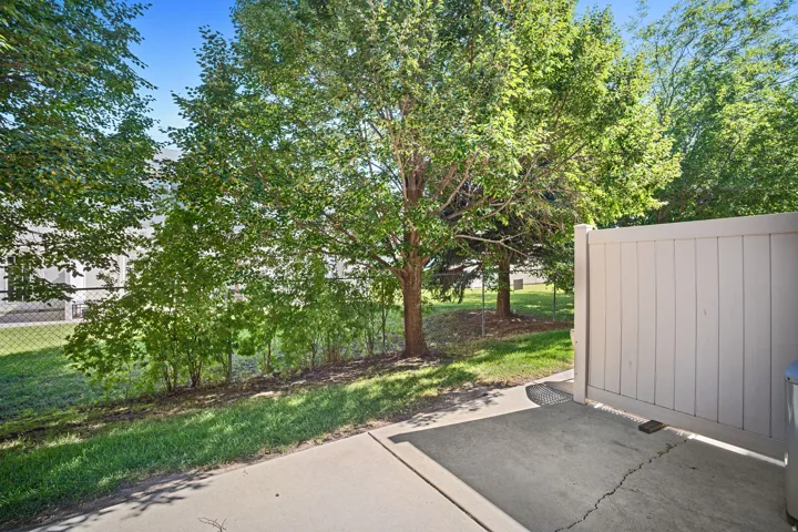 Patio space with concrete surfacing, bordered by a privacy fence