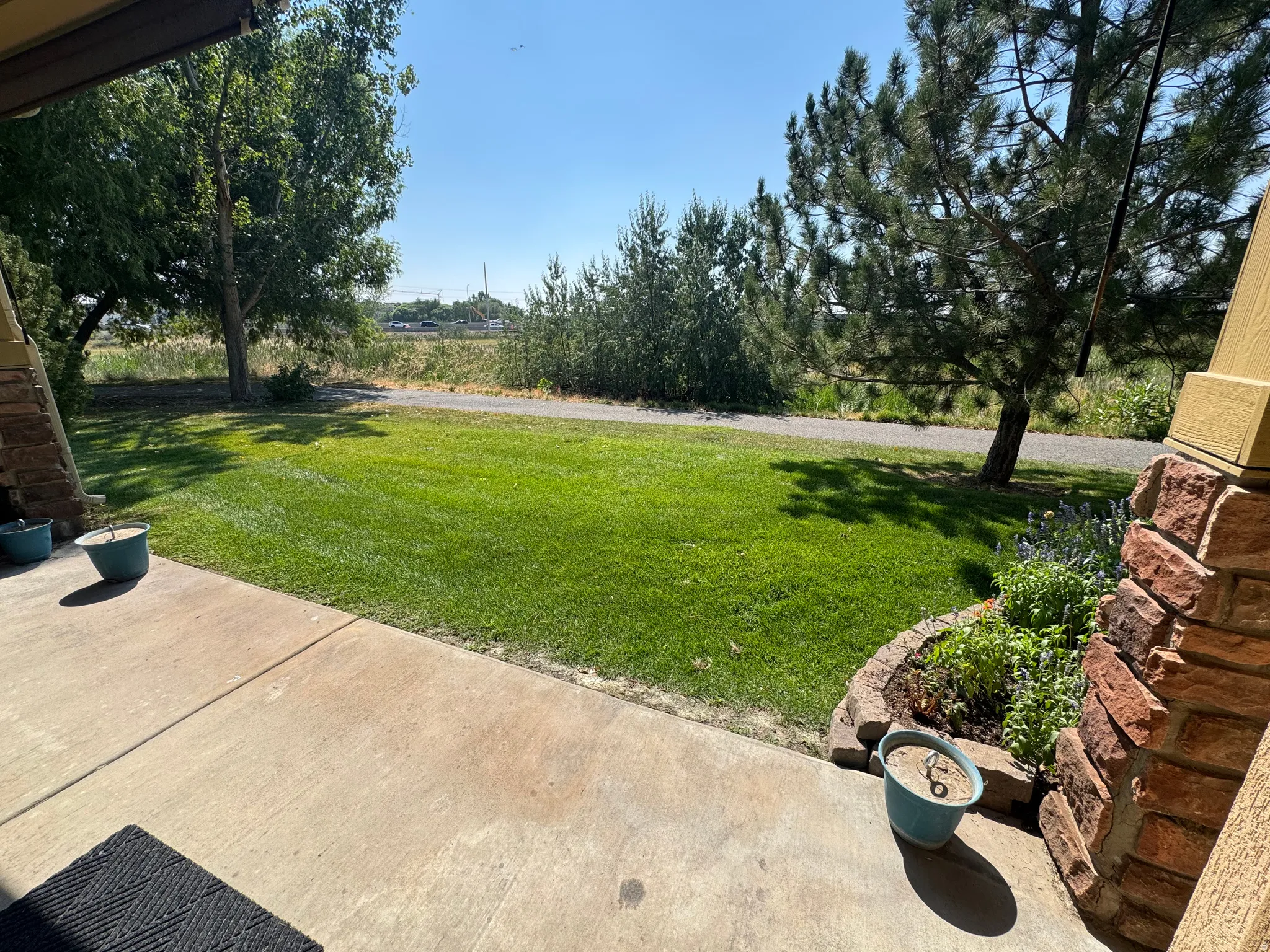 Expansive green lawn with mature trees and a gravel pathway