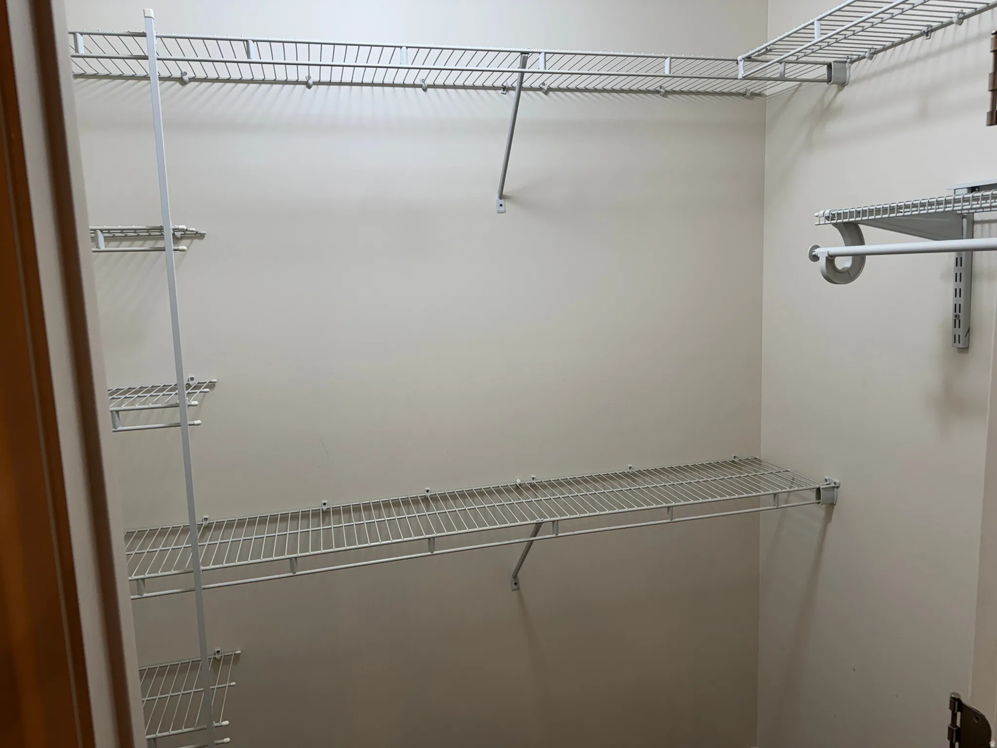 Walk-in closet featuring extensive wire shelving and hanging rods