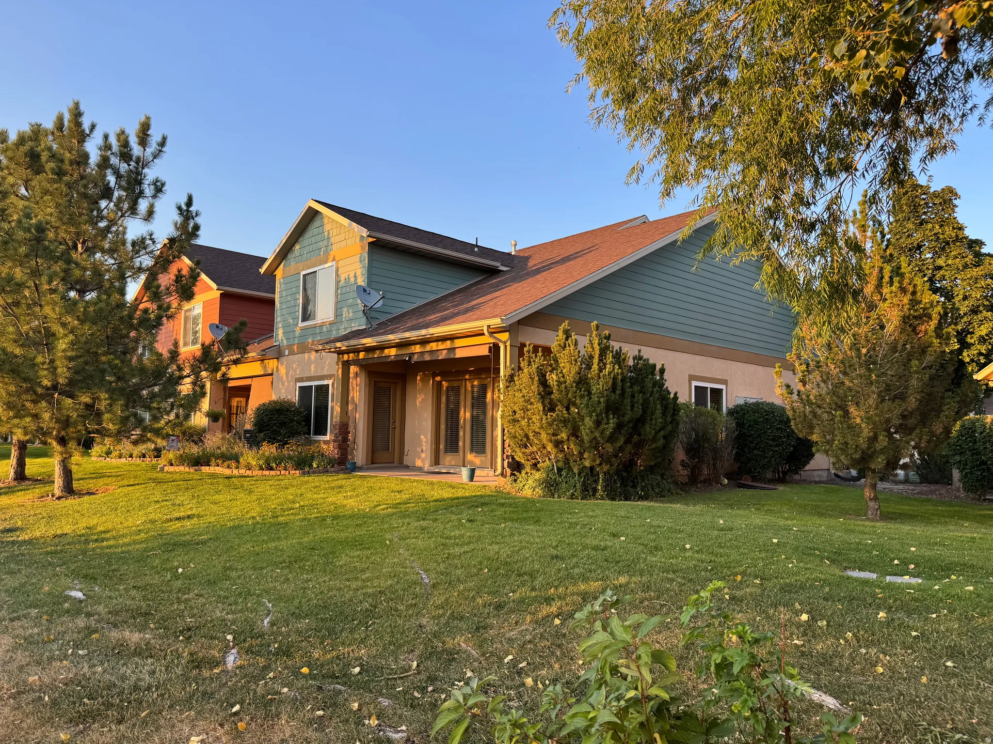 Modern farmhouse residence showcasing a striking two-tone exterior with warm golden siding and charcoal gray accents