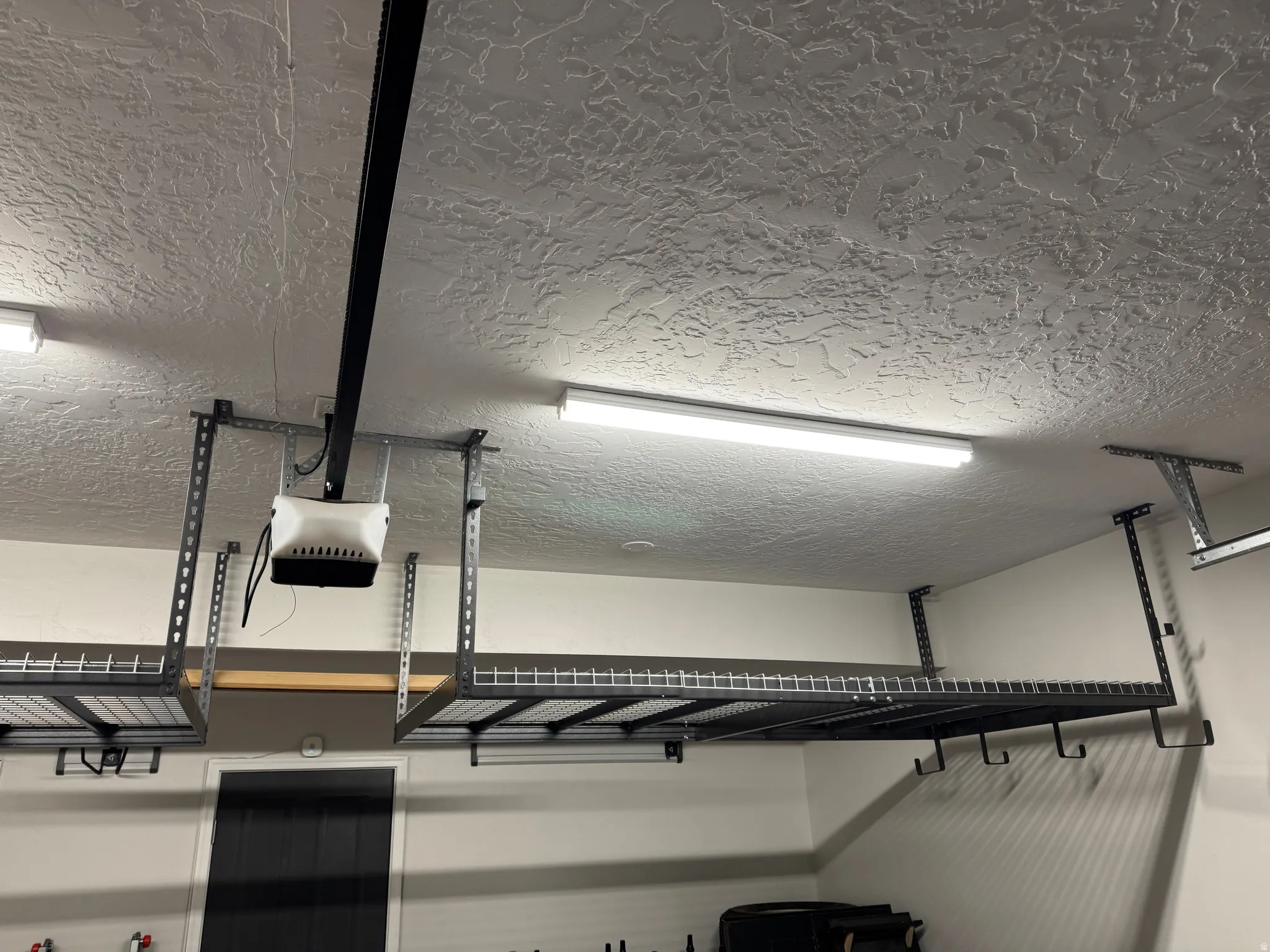 Garage featuring overhead storage racks, integrated lighting, and a textured ceiling finish