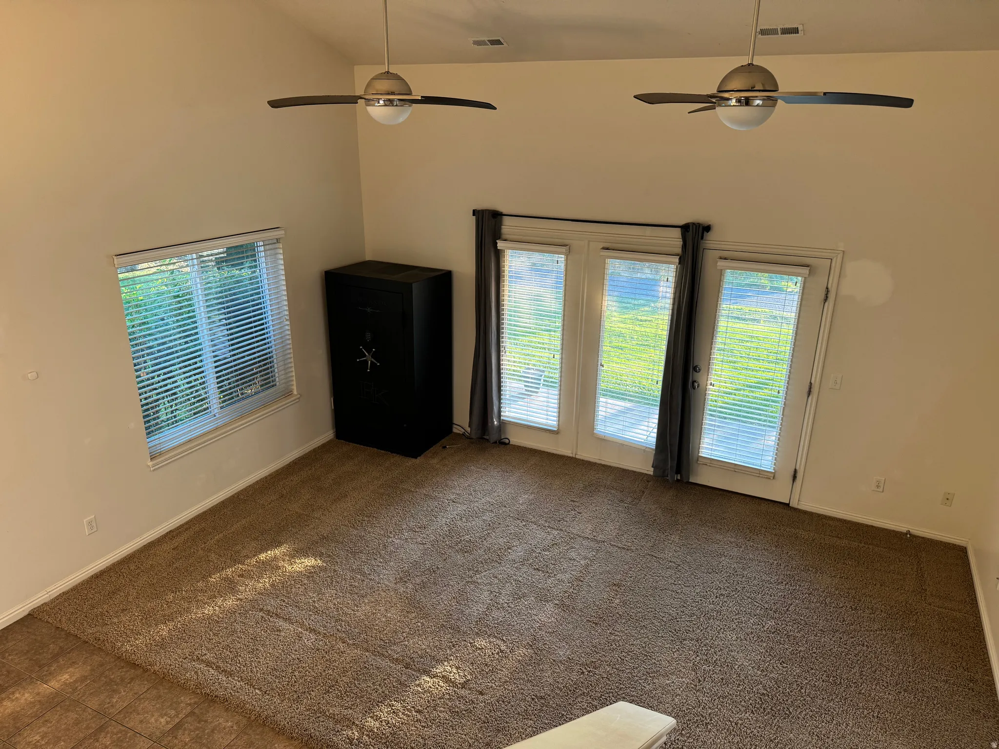 Spacious room with vaulted ceilings and dual ceiling fans