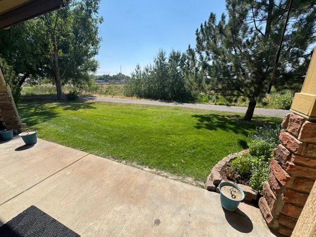 Expansive green lawn with mature trees and a gravel pathway
