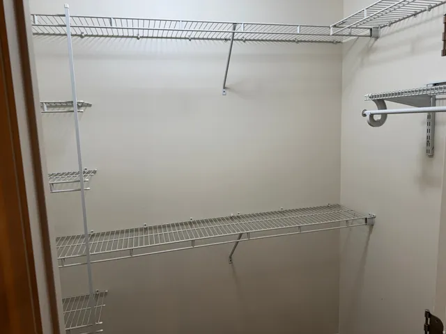 Walk-in closet featuring extensive wire shelving and hanging rods