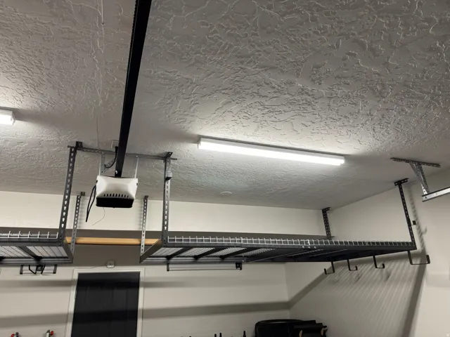 Garage featuring overhead storage racks, integrated lighting, and a textured ceiling finish