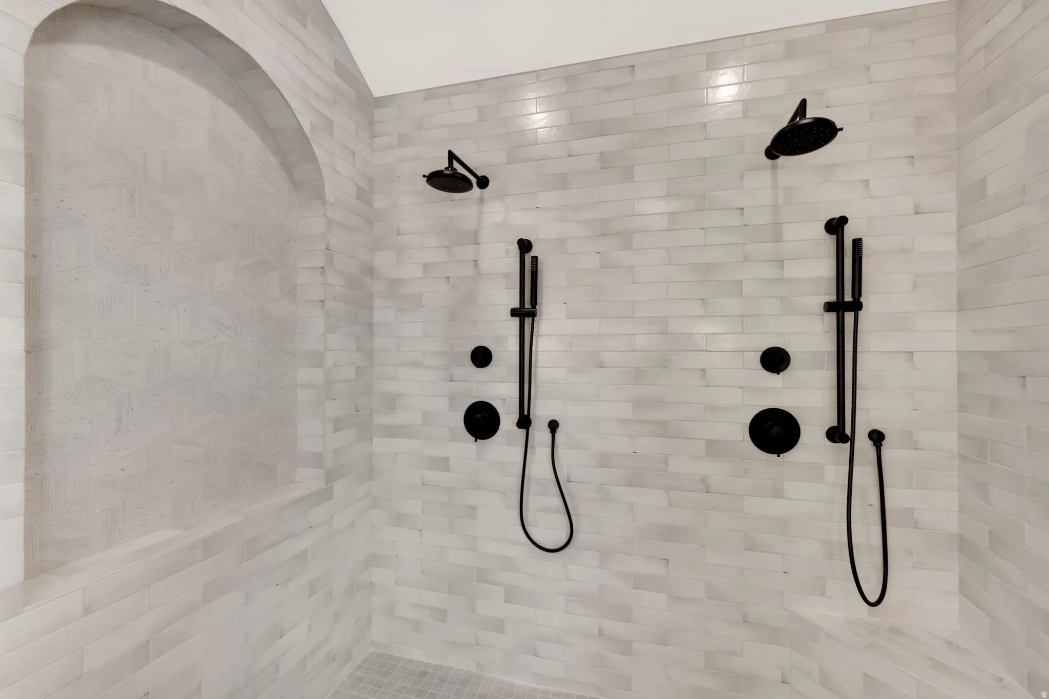 Master shower with dual shower heads and handheld wands, and a built-in arched alcove